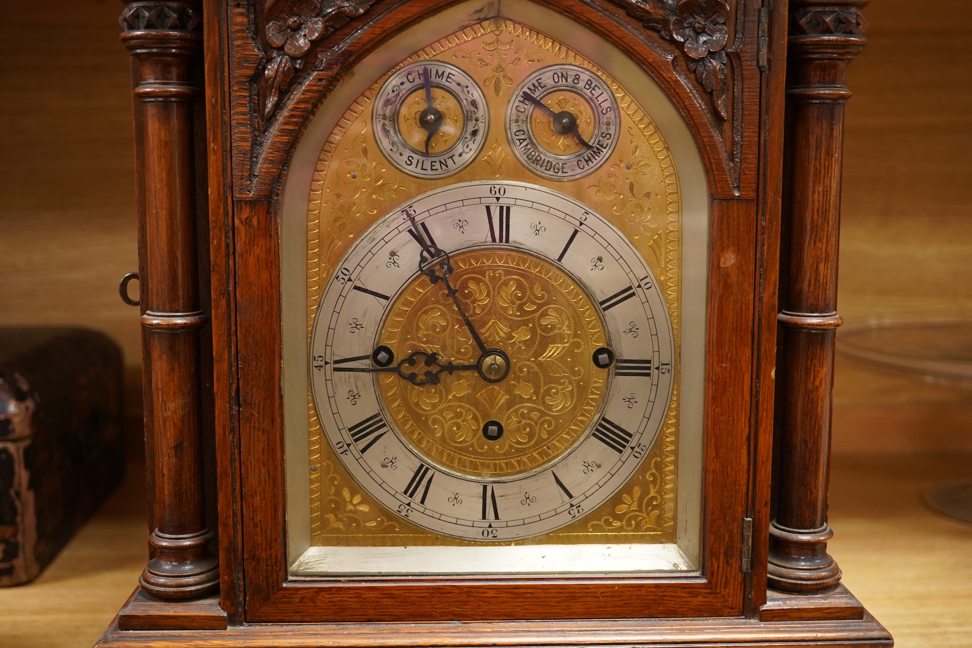 A German Gothic style oak mantel clock, early 20th century, with pendulum and keys, 49cm high